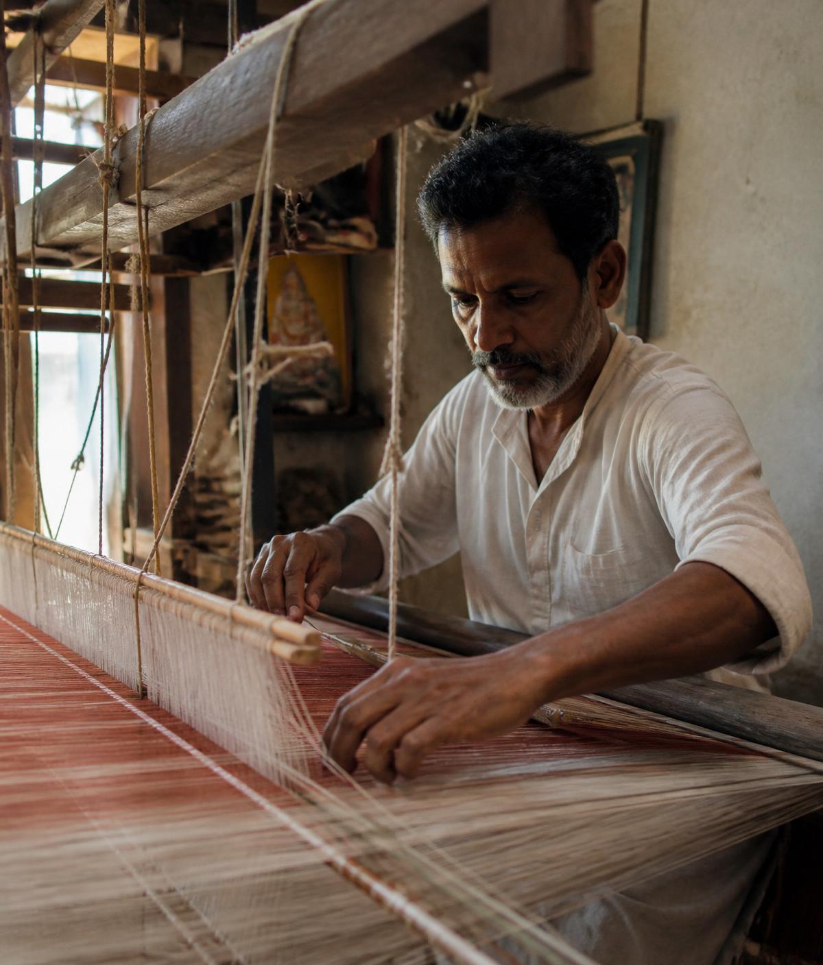 Artisan weaving handloom fabric on a traditional loom